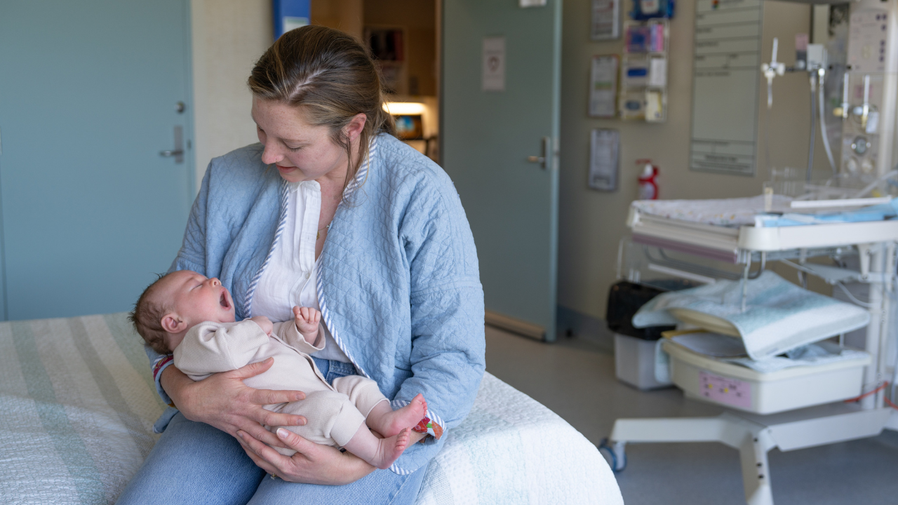 Mother holding a baby in a hospital room Mother holding a baby in a hospital room