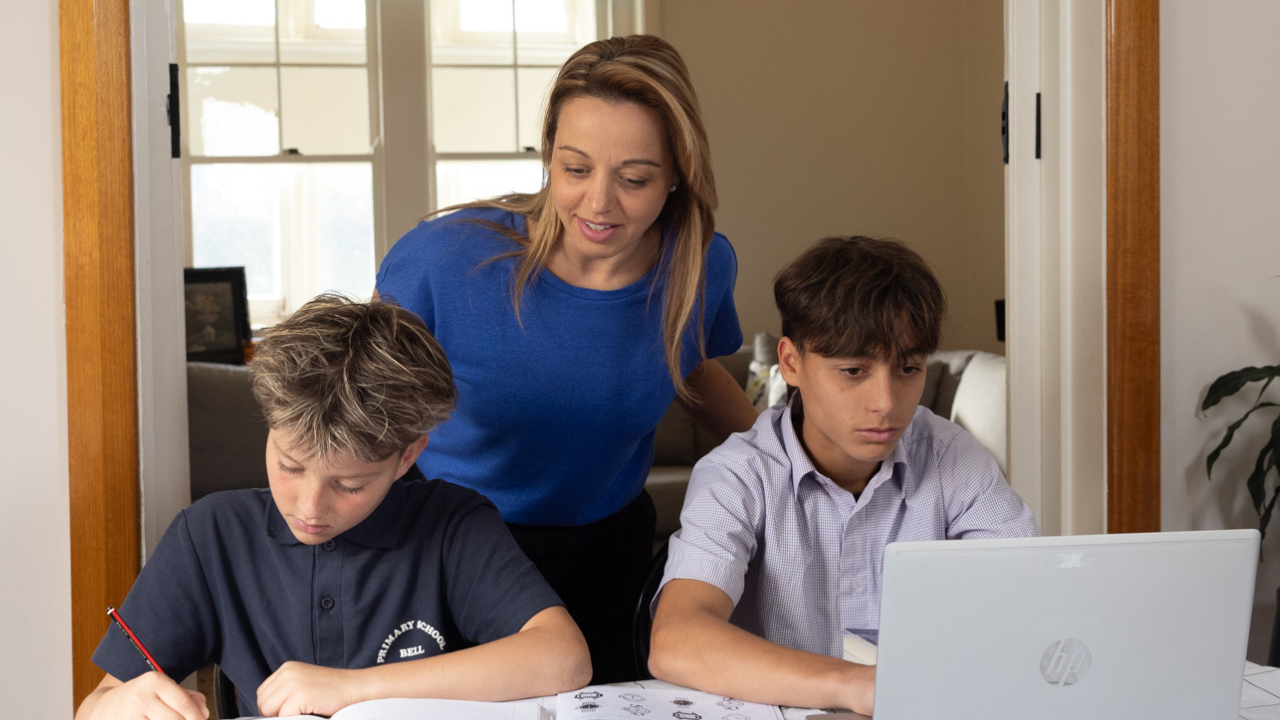 Mother with two children doing homework on a table Mother with two children doing homework on a table