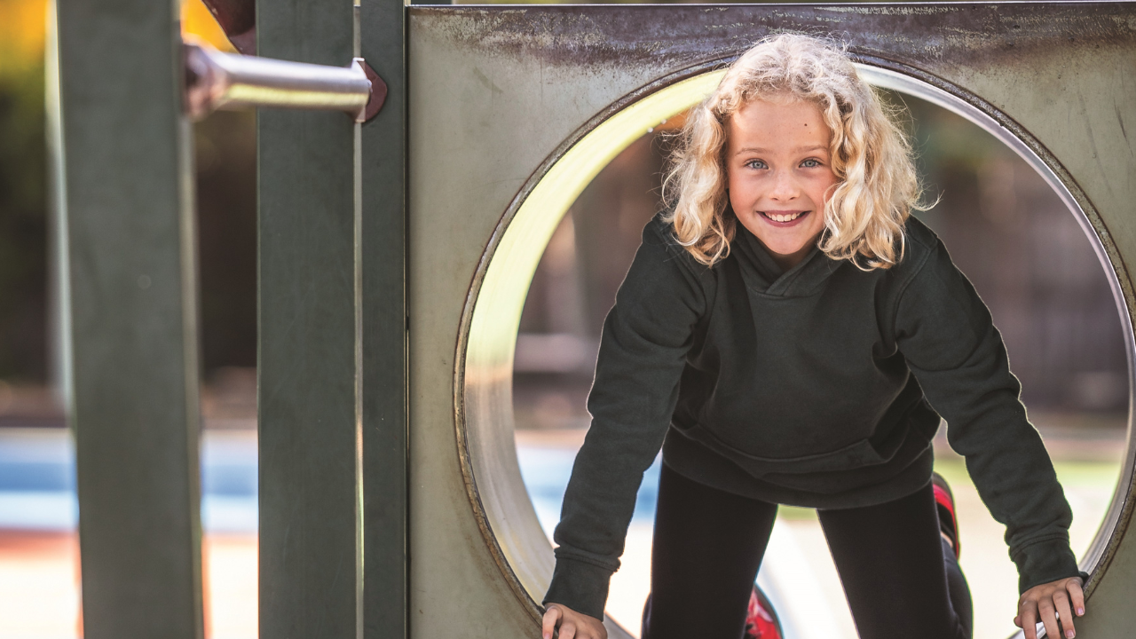 Young student on outdoor playground equipment Young student on outdoor playground equipment
